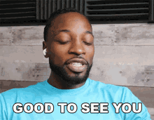 a man in a blue shirt says good to see you with his eyes closed