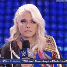 alexa bliss is holding a microphone in front of a blue background