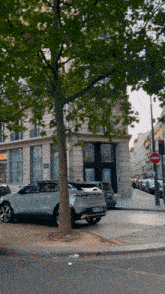 a white car is parked in front of a building with a no entry sign