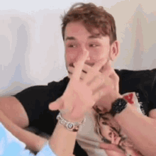 a man with a watch on his wrist is making a funny face .