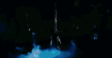 a person is hanging upside down from a pole in a dark room