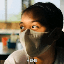 a woman wearing a face mask is laughing and says the word " hene "