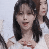 a girl making a heart shape with her hands with her mouth open