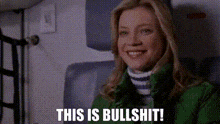 a woman in a green jacket is smiling and says `` this is bullshit ! ''