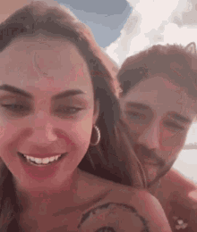 a man and a woman are smiling at the camera