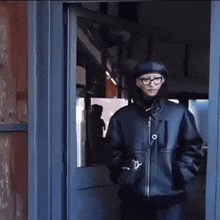a person wearing glasses and a black jacket with the letter y on it