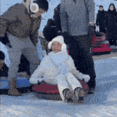 a group of people are sledding down a snow covered slope