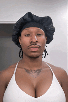 a man wearing a hat and a white tank top