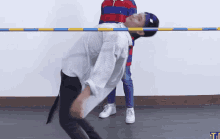 a person is holding another person 's head over a pole with the letter t on the bottom
