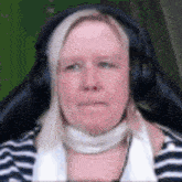 a woman wearing headphones is sitting in a chair .