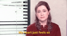 a woman is standing in front of a window with blinds and says `` my heart just feels so '' .