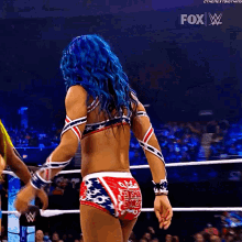 a woman with blue hair is in a wrestling ring with a fox logo