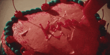 a heart shaped cake with cherries and frosting that says love