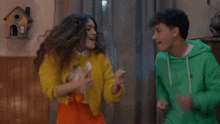 a boy and a girl are dancing in a living room .