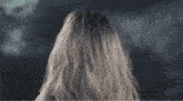 a close up of a woman 's face with long blonde hair .