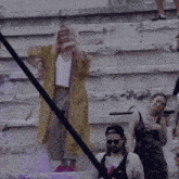a group of people are standing on a set of stairs and one of them is wearing sunglasses