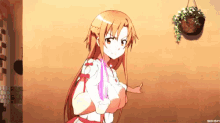 a girl with long red hair is holding a pink object .
