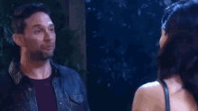 a man and a woman are looking at each other in the dark .