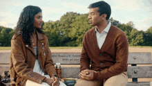 a man and a woman are sitting on a bench with a plaque that says david roebuck architect with all our