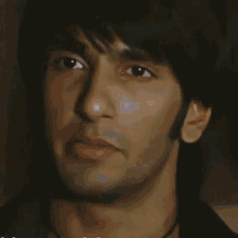 a close up of a man 's face with a black shirt