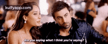 a man and a woman are sitting next to each other and the man is asking the woman what she thinks she is saying .