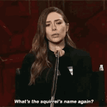 a woman is talking into a microphone and saying `` what 's the squirrel 's name again '' .