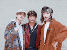 three young men are posing for a picture and one of them is wearing a hat
