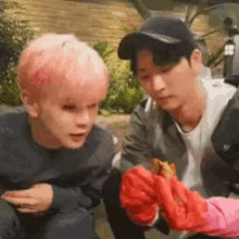 a man with pink hair is sitting next to another man .