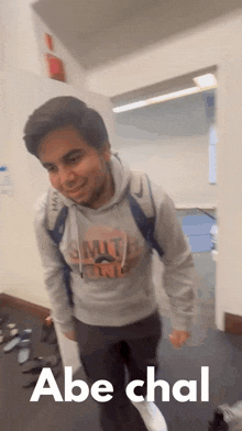 a man wearing a sweatshirt that says smith on it is walking down a hallway