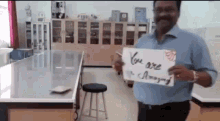 a man is holding up a sign that says you are amazing