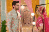 a bride and groom are standing next to each other and the bride is wearing a pink dress