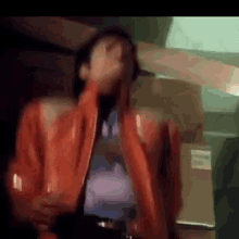 a person wearing a red jacket is covering their mouth with their hand .