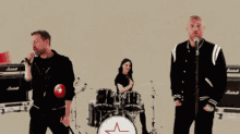 a group of people singing in front of a drum set with the words ra ra raspu teen above them