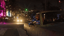 a woman is leaning out of a car window at night .