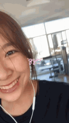a girl wearing headphones is smiling and the word gym is on the bottom