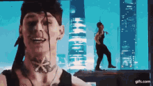 a man with dreadlocks and a tattoo on his neck is dancing on a stage .