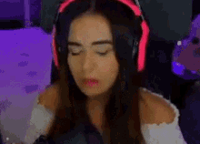 a woman wearing headphones is sitting in front of a computer monitor .
