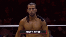 a shirtless wrestler named rhett titus is in a wrestling ring