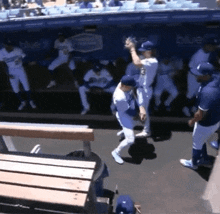 a group of baseball players standing in front of a dugout with the word blue on it