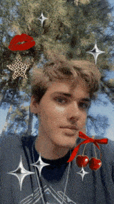 a young man is wearing a black shirt with cherries and a red bow
