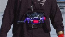 a person is holding a purple item with a red button on it