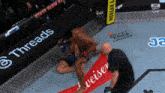 a fighter is laying on the ground in front of a budweiser advertisement