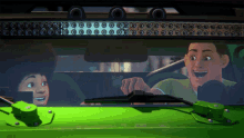 a man is driving a green car with a boy in the back