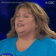 a woman wearing a blue shirt that says family feud canada on the front