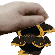 a hand is holding a stuffed animal that looks like a cartoon character .