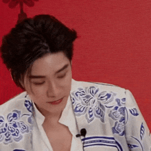 a man is wearing a white shirt with blue flowers on it