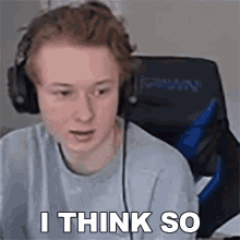 a young man wearing headphones is sitting in a chair and saying i think so .