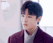 a young man wearing a purple jacket and a white shirt
