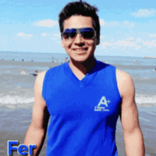 a man wearing sunglasses and a blue tank top with the word fer on the bottom right