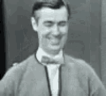 a black and white photo of a man in a suit and bow tie .